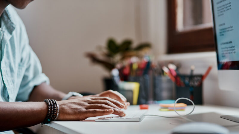 A business owner oitting at a desk, typing AI comands into his PC