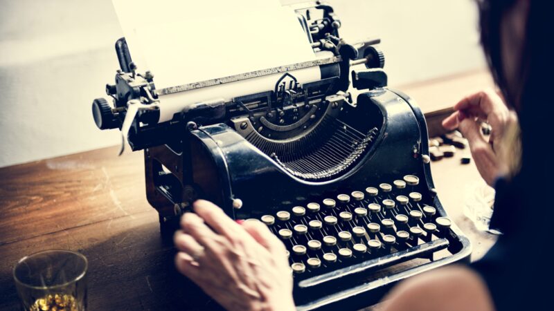 Writer using vintage typewriter to symbolise authentic human content and modern SEO strategy