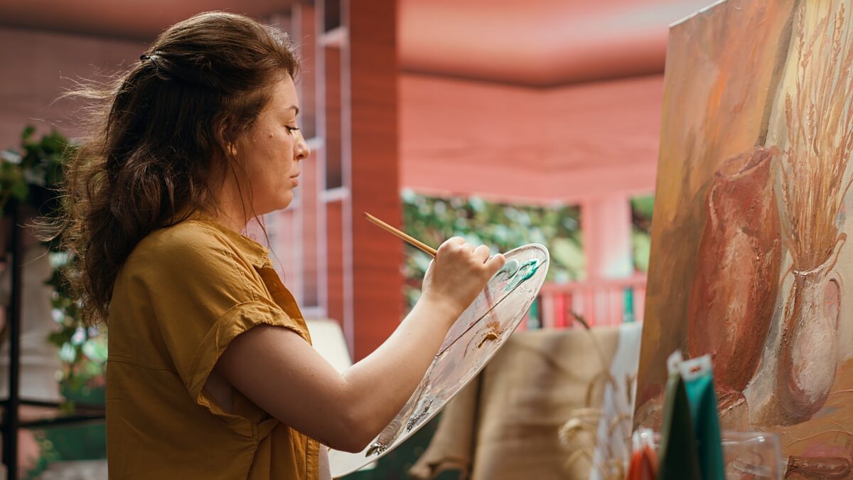 Artist painting on canvas representing human creativity, authentic content creation, and the future of SEO